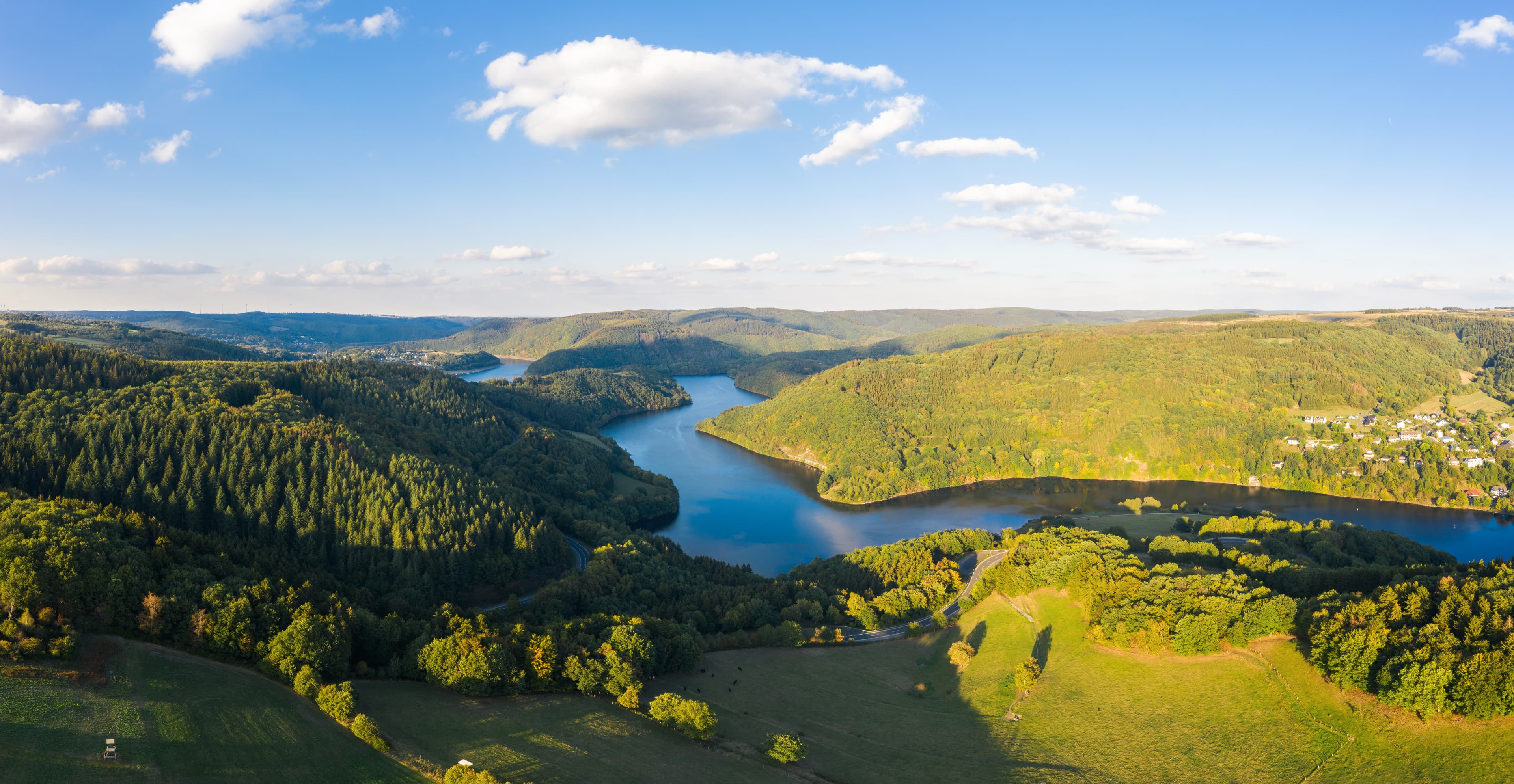 Ruhiger Uferbereich am Rursee mit Blick auf die bewaldeten Hänge